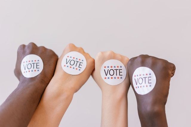 4 hands with VOTE stickers on each